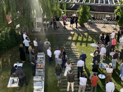 Teilnehmer beim Strategiedialog-Sommerfest im Garten, Gespräche und Networking im Freien.